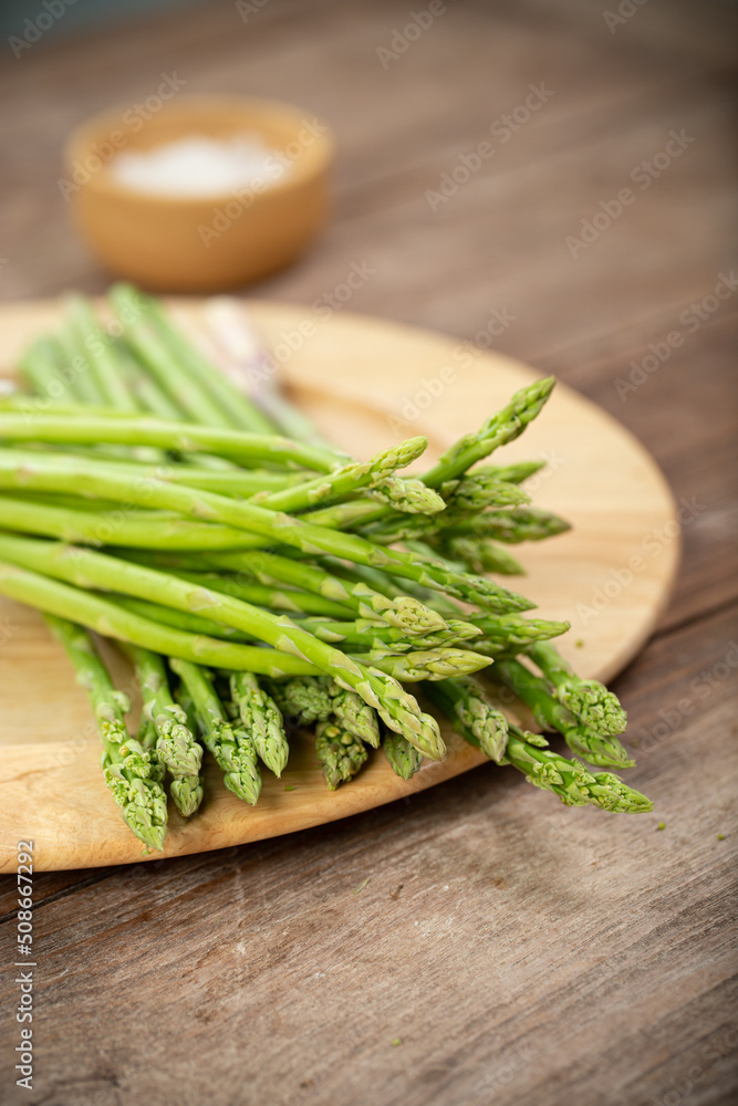 Asparagus is green and straight vegetable. Fresh, green asparagus is crispy for cook on wood table with salt Asparagus is green and straight vegetable. Fresh, green asparagus is crispy for cook on wood table with salt