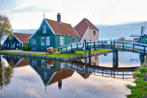 April 13 2022, Zaanse Schans, Netherlands, Authentic wooden Dutch houses on the banks of the river Zaan. Reflections in the water.