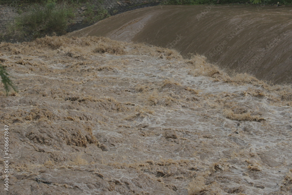 Torrential stream of water flowing through the dam close up
