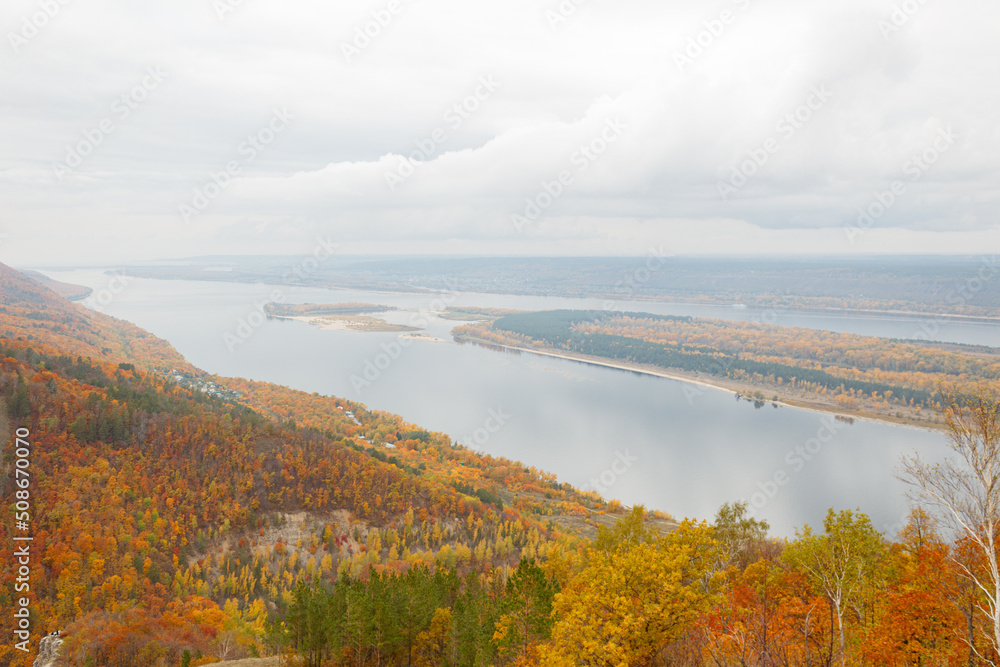 Mountain, observation deck overlooking the Volga River. A river with an island on the background of a mountain autumn forest. Space for copying. The sky is overcast. Mountain, observation deck overlooking the Volga River. A river with an island on the background of a mountain autumn forest. Space for copying. The sky is overcast.