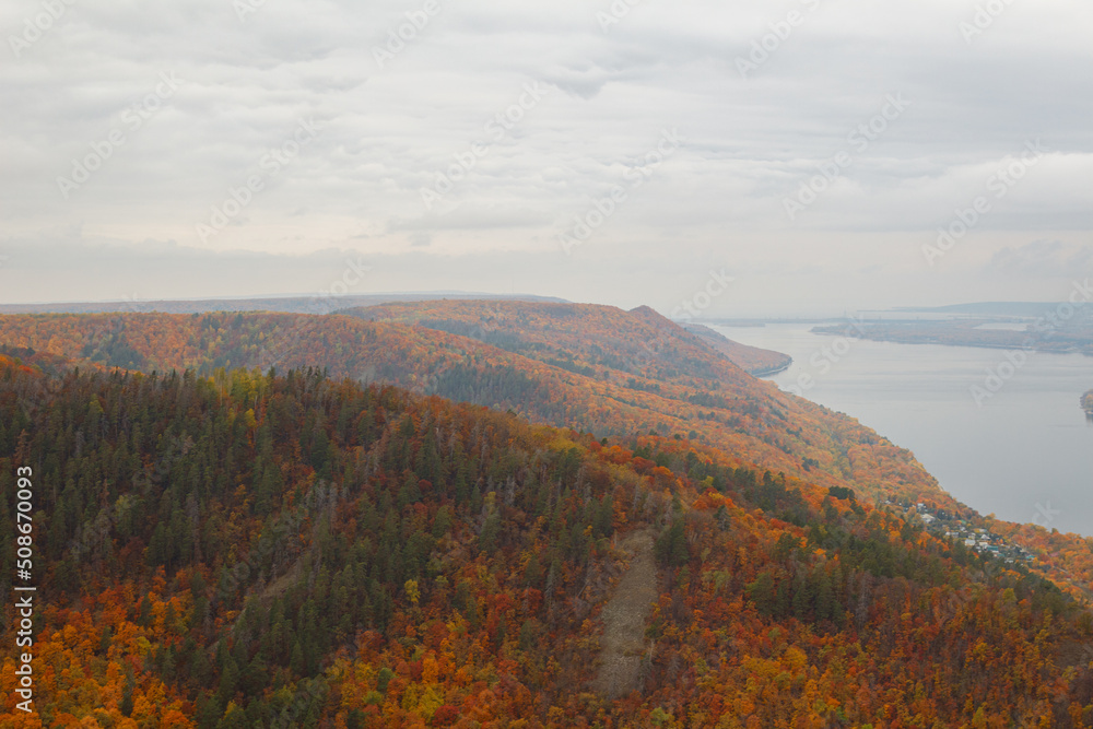 Mountain, observation deck overlooking the Volga River. A river with an island on the background of a mountain autumn forest. Space for copying. The sky is overcast.