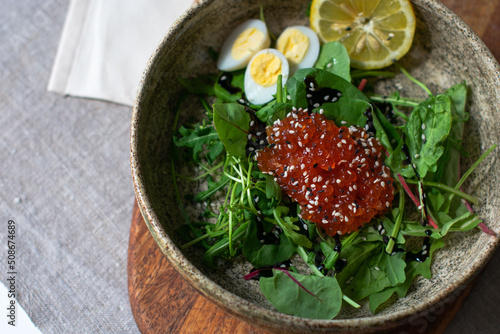 salad with red caviar and quail eggs serving food