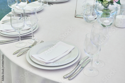 Photo Table setting with sparkling wineglasses, plate with white napkin and cutlery on table, copy space