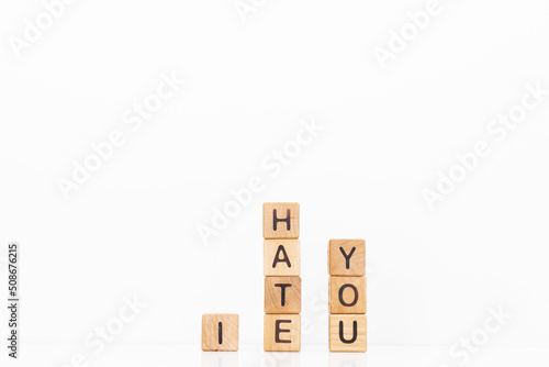 I hate you word is written on wooden cubes on a white background. Closeup of wooden elements