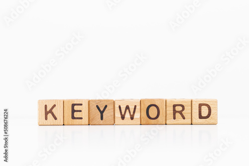 Keyword word is written on wooden cubes on a white background. Closeup of wooden elements