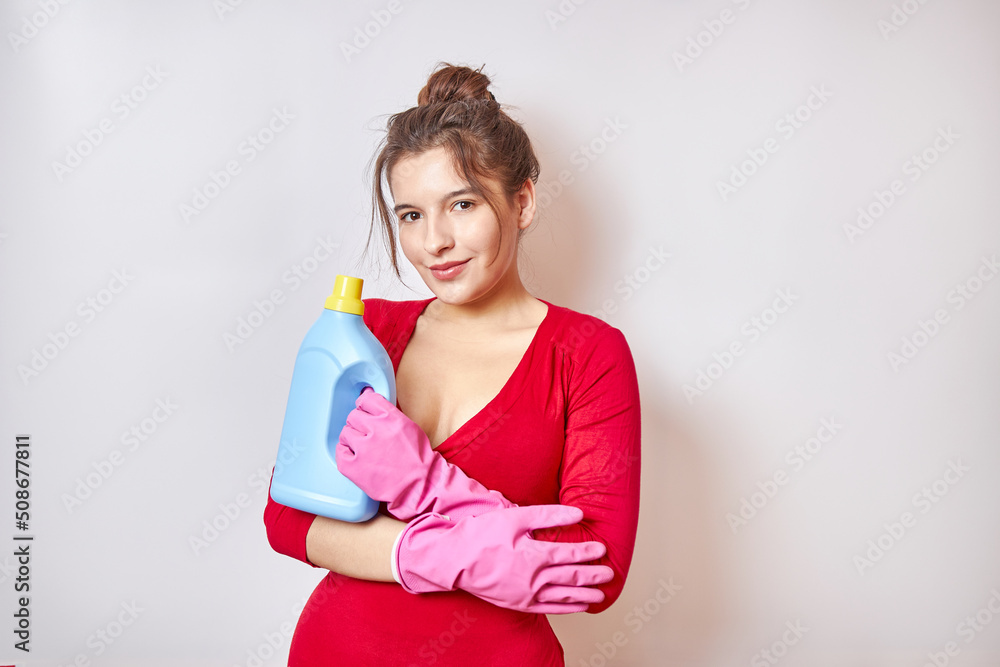 Beautiful girl in a red shirt holds detergents. Beautiful girl in a red shirt holds detergents.