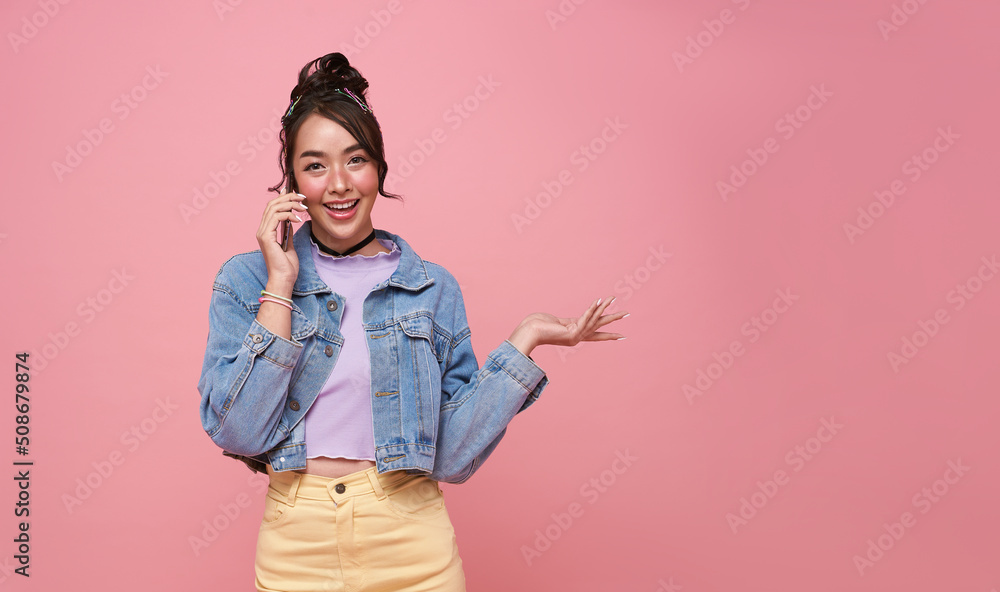Happy young Asian teen woman talking mobile phone isolated on studio pink background. Happy young Asian teen woman talking mobile phone isolated on studio pink background.