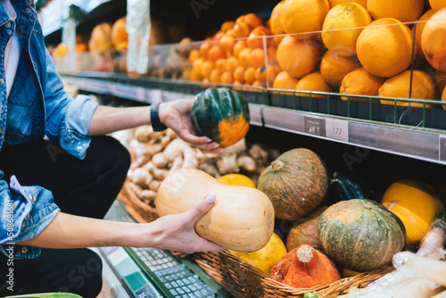 Unrecognizable girl choosing pumpkin in supermarket © progressman