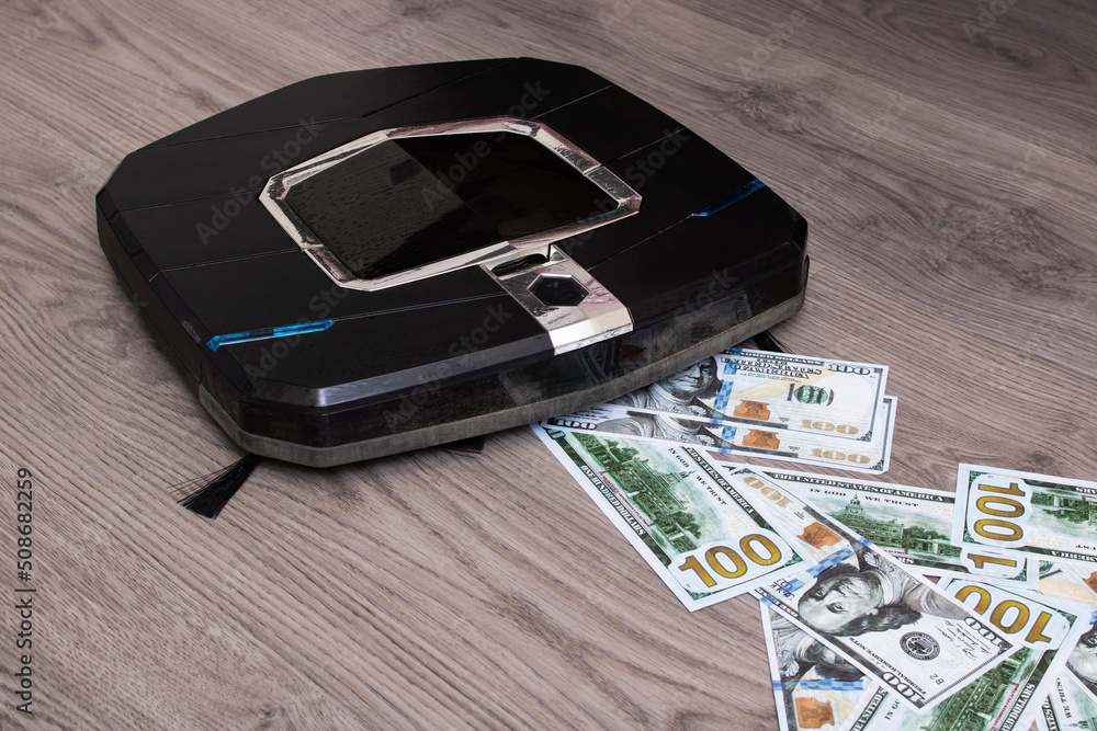 Robot vacuum cleaner sucks in dollars closeup Robot vacuum cleaner sucks in dollars closeup
