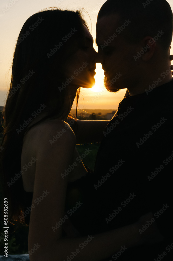 Silhouette of a loving couple kissing at sunset