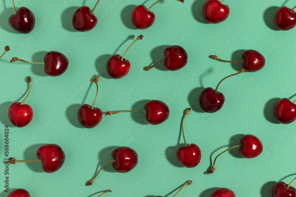 Sweet red cherries on a turquoise background. Top view. Sweet red cherries on a turquoise background. Top view.