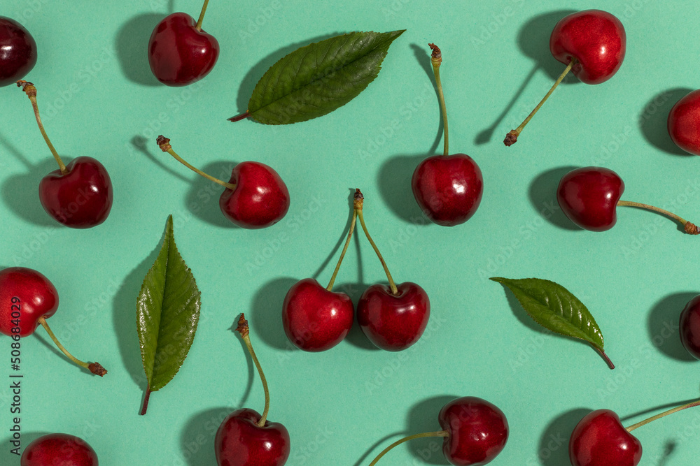 Sweet red cherries on a turquoise background. Top view. Sweet red cherries on a turquoise background. Top view.