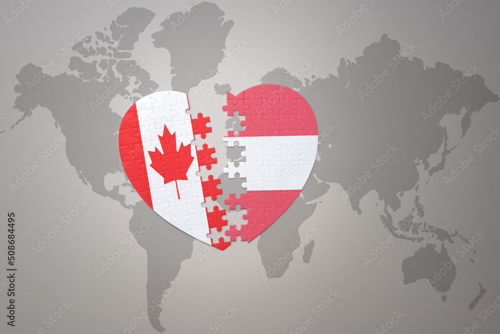 puzzle heart with the national flag of canada and austria on a world map background.Concept. puzzle heart with the national flag of canada and austria on a world map background.Concept.