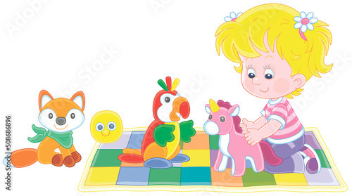 Fototapeta Naklejka Na Ścianę i Meble -  Happy little girl playing with a funny soft toy unicorn, a parrot and a fox on a colorful checkered carpet in a nursery, vector cartoon illustration isolated on a white background