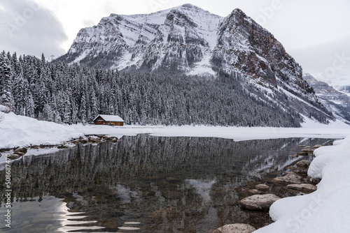 Lake Louise, Alberta, Canada - Incredible mountain scenery in winter time with reflection of trees in water below.  photo