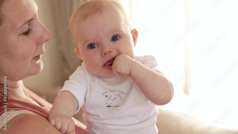 Young mother is playing with her little baby girl in a nursery in a morning at home. Parenthood, childhood, life, maternity, motherhood concept Young mother is playing with her little baby girl in a nursery in a morning at home. Parenthood, childhood, life, maternity, motherhood concept