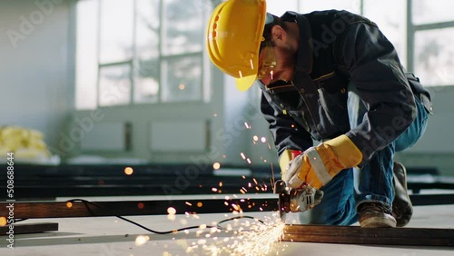 Good equipment constructor worker at construction site using the disc welding machine and cut the metals and creating big sparks