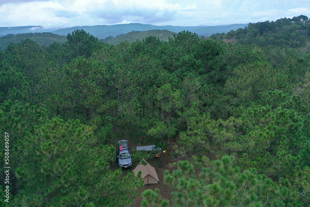 Aerial view. Group of friends sitting outside enjoying, relaxation nature on the hills in the twilight. Travel, tour adventure on nature, vacation and friendship, happy camper. Friends camping sitting
