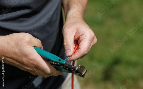 Wire cutters, held in hands cutting an electrical cable
