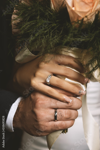 Print op canvas Hands of groom and bride at wedding with bouquet and rings