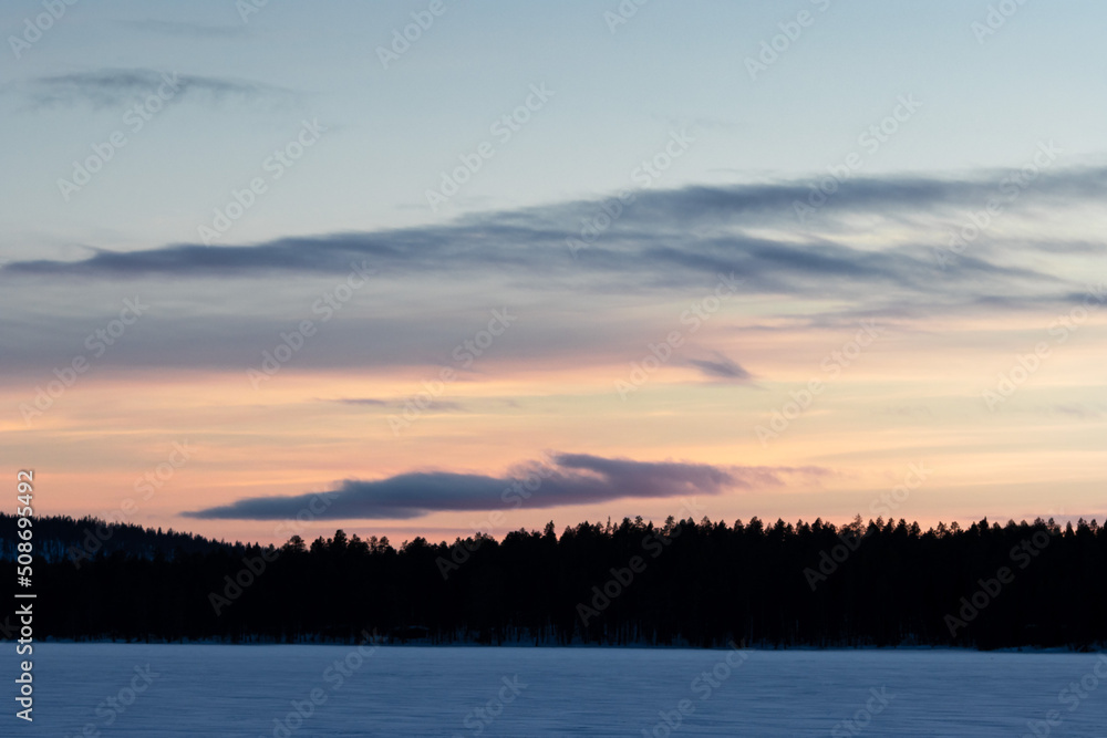 stunning sunset orange sky above trees in finnish lapland