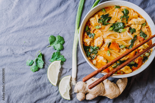Thai red curry noodle soup with chicken in a bowl