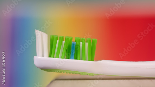 Close up view of green tooth brush against colorful background