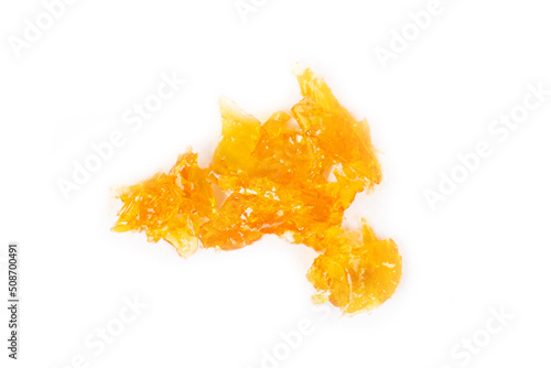 golden drops cannabis wax close up macro on white background.