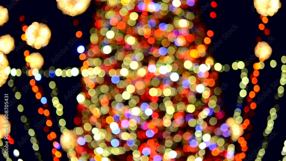 Large New Year's Christmas tree decorated with luminous multi-colored garlands and illumination at night. Christmas tree with flashing lights. Blurred background. New Year and Christmas holidays Large New Year's Christmas tree decorated with luminous multi-colored garlands and illumination at night. Christmas tree with flashing lights. Blurred background. New Year and Christmas holidays