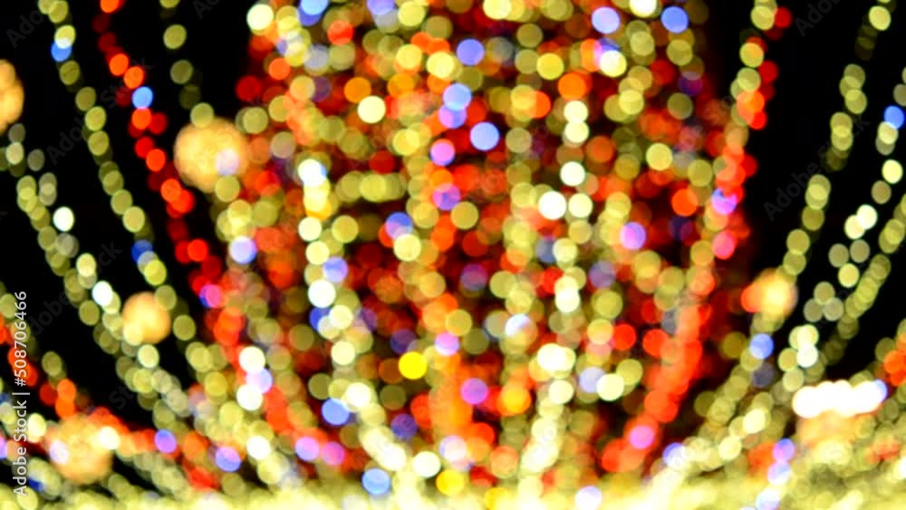 Large New Year's Christmas tree decorated with luminous multi-colored garlands and illumination at night. Christmas tree with flashing lights. Blurred background. New Year and Christmas holidays Large New Year's Christmas tree decorated with luminous multi-colored garlands and illumination at night. Christmas tree with flashing lights. Blurred background. New Year and Christmas holidays