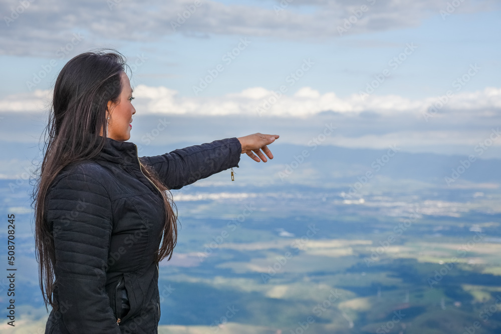 Mulher apontando para uma vista de cima da montanha Mulher apontando para uma vista de cima da montanha