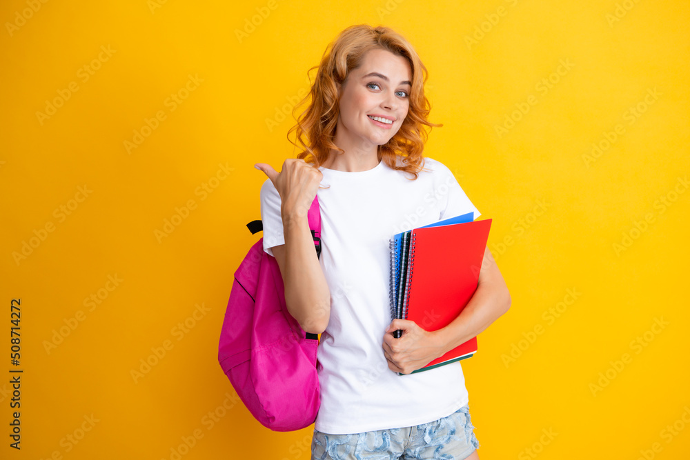 Portrait of happy woman holding backpack. Study process. Young cute student girl with backpack holds some documents and books over yellow background. Portrait of happy woman holding backpack. Study process. Young cute student girl with backpack holds some documents and books over yellow background.
