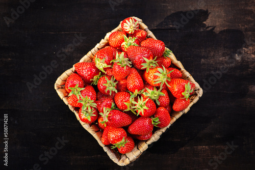 Strawberries in a basket on a wooden table