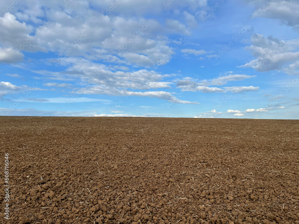 Furrows row pattern in a plowed field prepared for planting crops in spring. Horizontal view in perspective Furrows row pattern in a plowed field prepared for planting crops in spring. Horizontal view in perspective