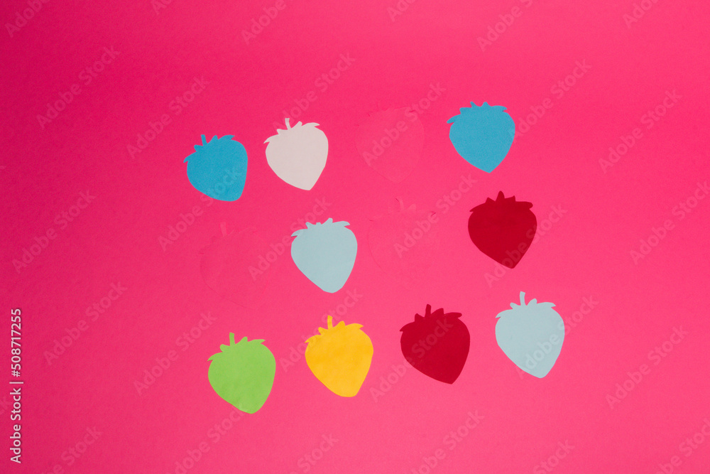 colorful paper strawberries on a pink background, creative summer design, fresh organic food