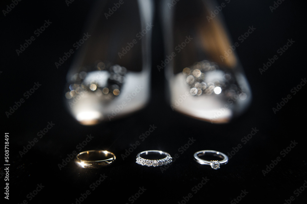 Three rings on the background of wedding shoes Three rings on the background of wedding shoes