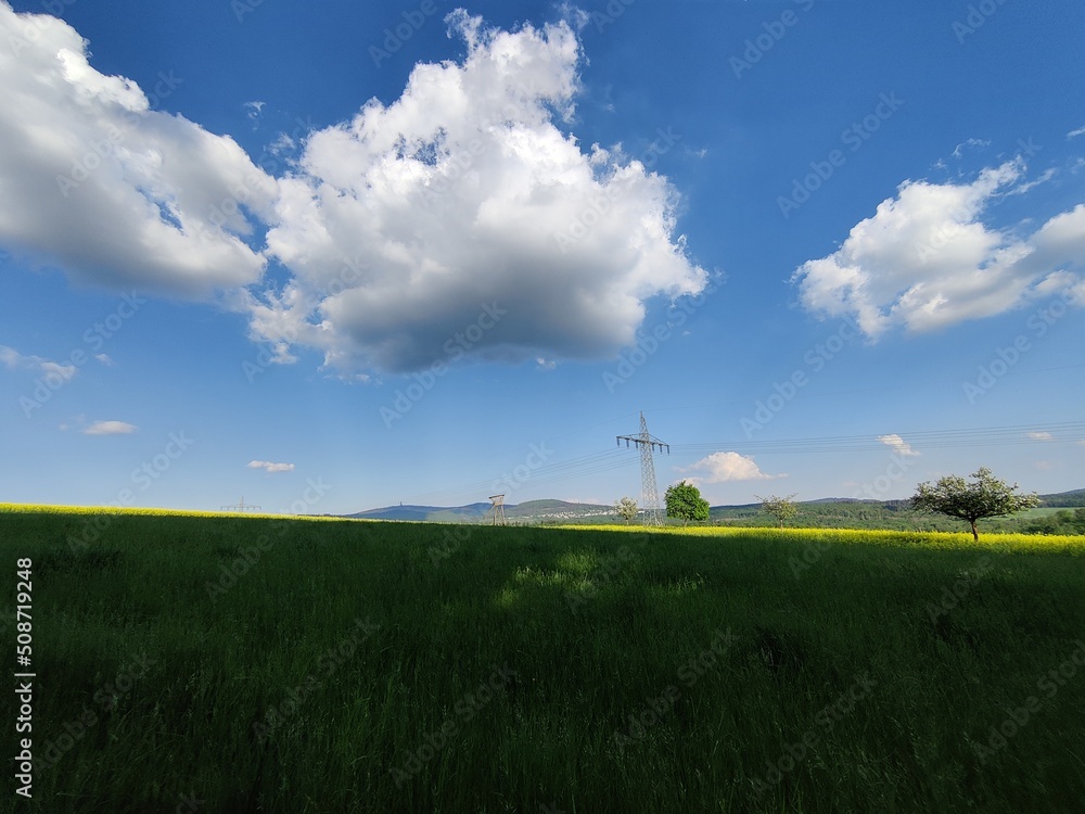 Eine große Wolke sieht dreidimensional aus und schwebt schwerelos im blauen Himmel im Frühling auf dem idyllischen Land Eine große Wolke sieht dreidimensional aus und schwebt schwerelos im blauen Himmel im Frühling auf dem idyllischen Land