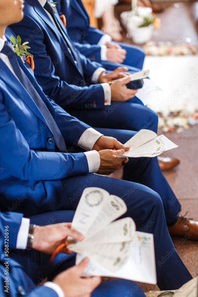 Obraz premium Stylish groomsmen sit during the ceremony in the church