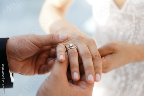 The groom wears a ring to the bride