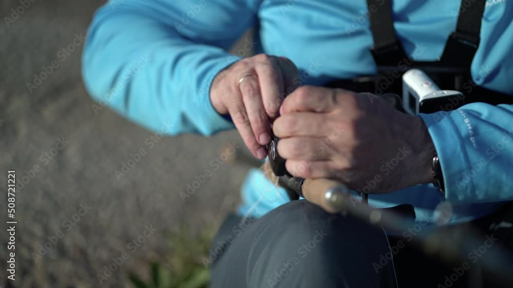 The fisherman untangles the fishing line in the reel for catching predatory fish