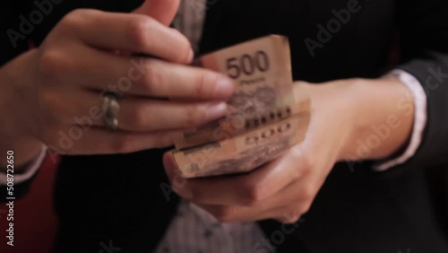 Manos de mujer contando dinero en billetes de quinientos pesos mexicanos photo