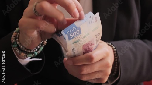 Manos de mujer contando billetes de quinientos pesos  photo
