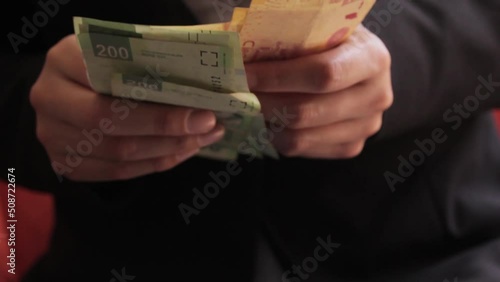 Manos de mujer contando dinero en billetes de docientos y cien pesos mexicanos photo