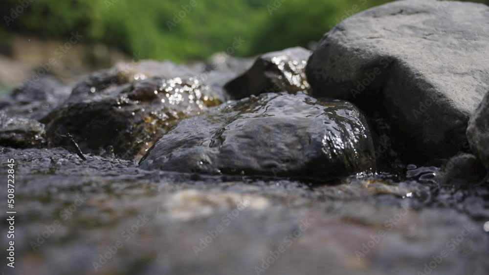 Water flowing over rocks in stream, close up shot of Nature Water flowing over rocks in stream, close up shot of Nature