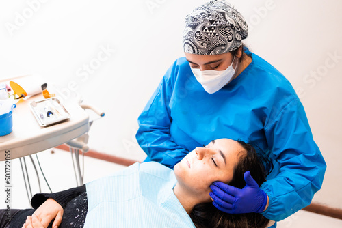 Female dentist doing an maxillofacial exam to a female patient  photo