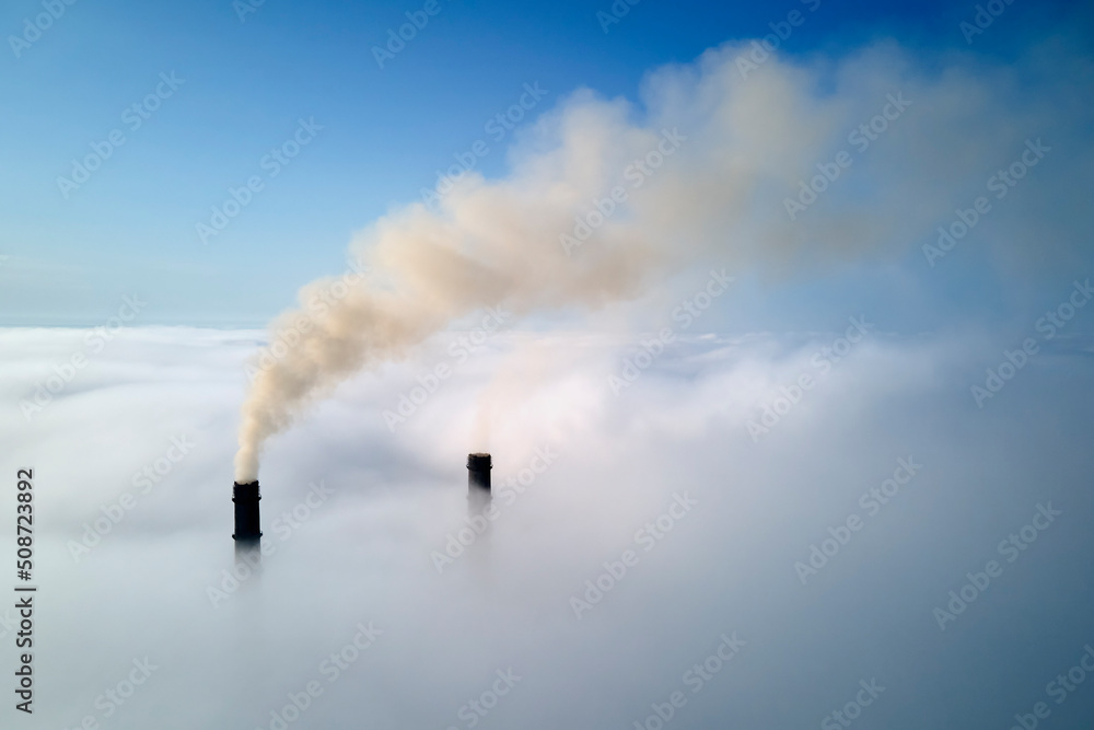 Coal power plant high pipes with black smoke moving upwards over clouds polluting atmosphere. Production of electrical energy with fossil fuel concept Coal power plant high pipes with black smoke moving upwards over clouds polluting atmosphere. Production of electrical energy with fossil fuel concept