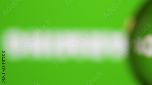 Passing in front of a glass ball with dolly and we read message about nature on the screen behind against green background. 4K native resolution.
