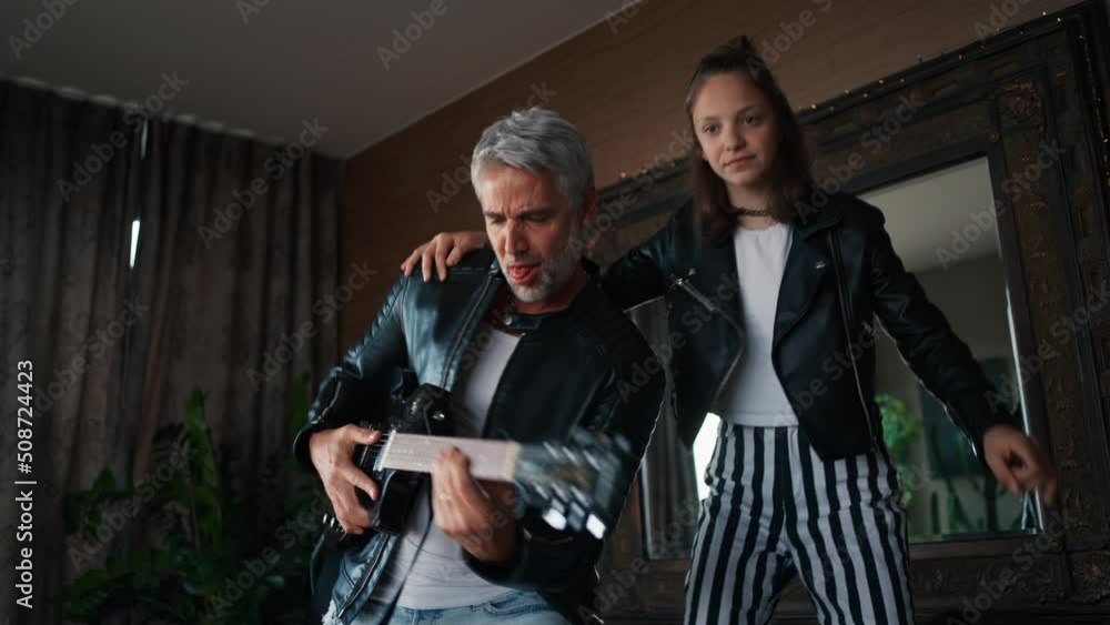 Father rock guitarist having fun and and dancing with his teenage daughter at home. Father rock guitarist having fun and and dancing with his teenage daughter at home.