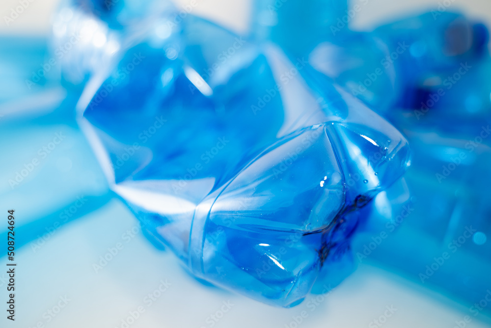 Blue plastic PET bottle in close up on white background. Focus on details