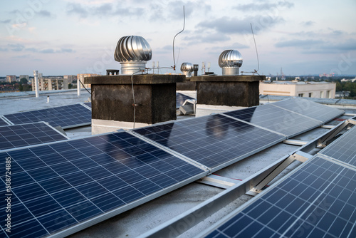 Solar panels located on the roof of the block. Green energy in modern city.